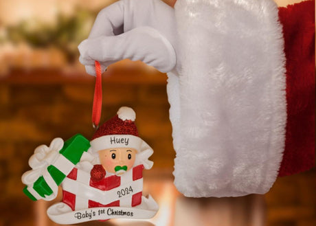 Baby 1st xmas ornament on santa hand