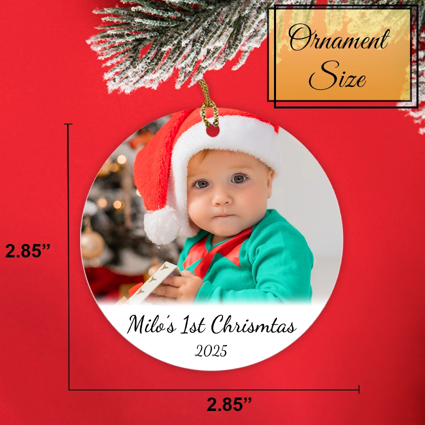 Christmas ornament with a baby in a Santa hat and green outfit, labeled 'Milo's 1st Christmas 2025', on a red background. Shows the size of the ornament 2.85 in x 2.85 in.