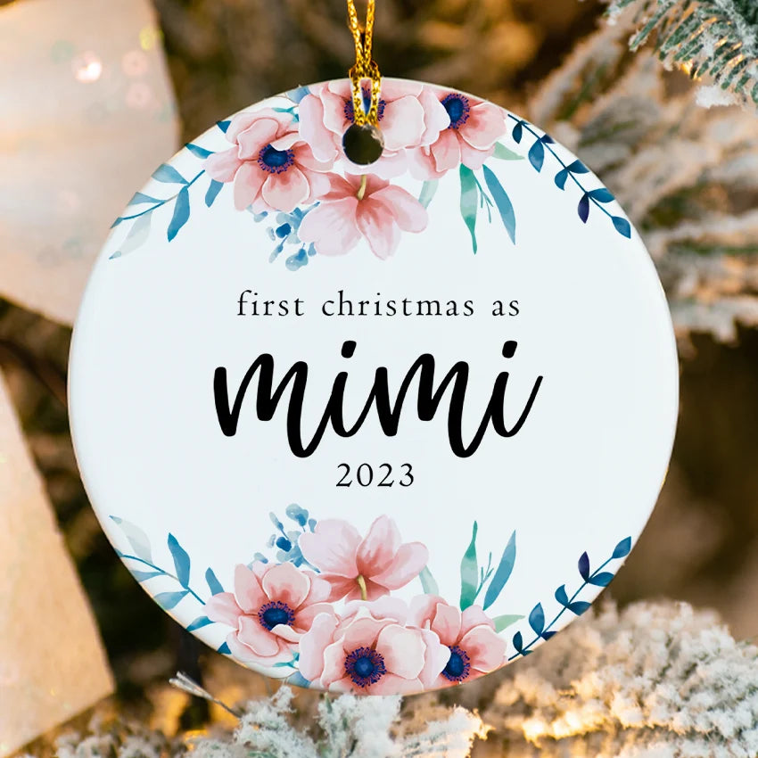 Decorative ornament with floral design and text 'first christmas as mimi 2023' on a Christmas tree.