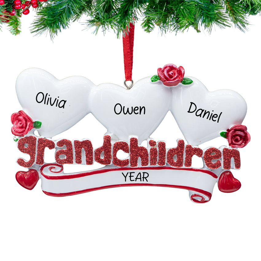 Grandchildren” ornament with three hanging hearts, each personalized with a child’s name and 2025, on a snowy Christmas tree branch.