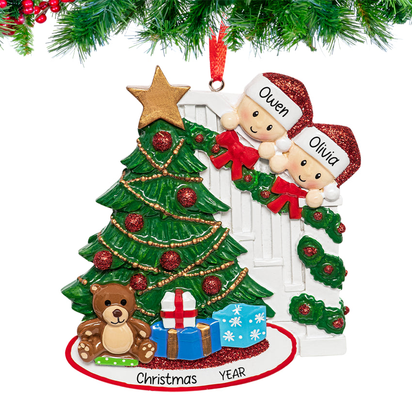 Personalized ornament of a smiling couple peeking from behind a decorated Christmas tree with names and 2025 engraved.