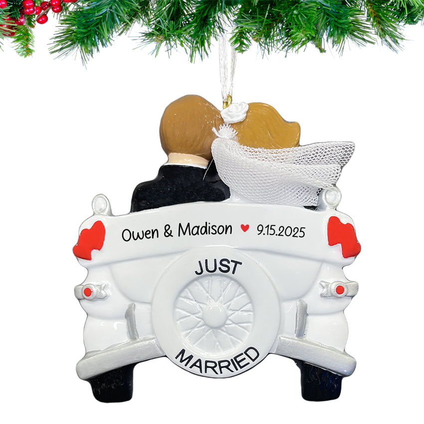 Decorative ornament of a couple in a wedding car with 'Just Married' text, hanging against a white background.