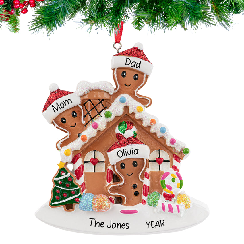 Gingerbread house ornament with a smiling family , personalized with names and 2025, hanging on a festive Christmas tree branch.