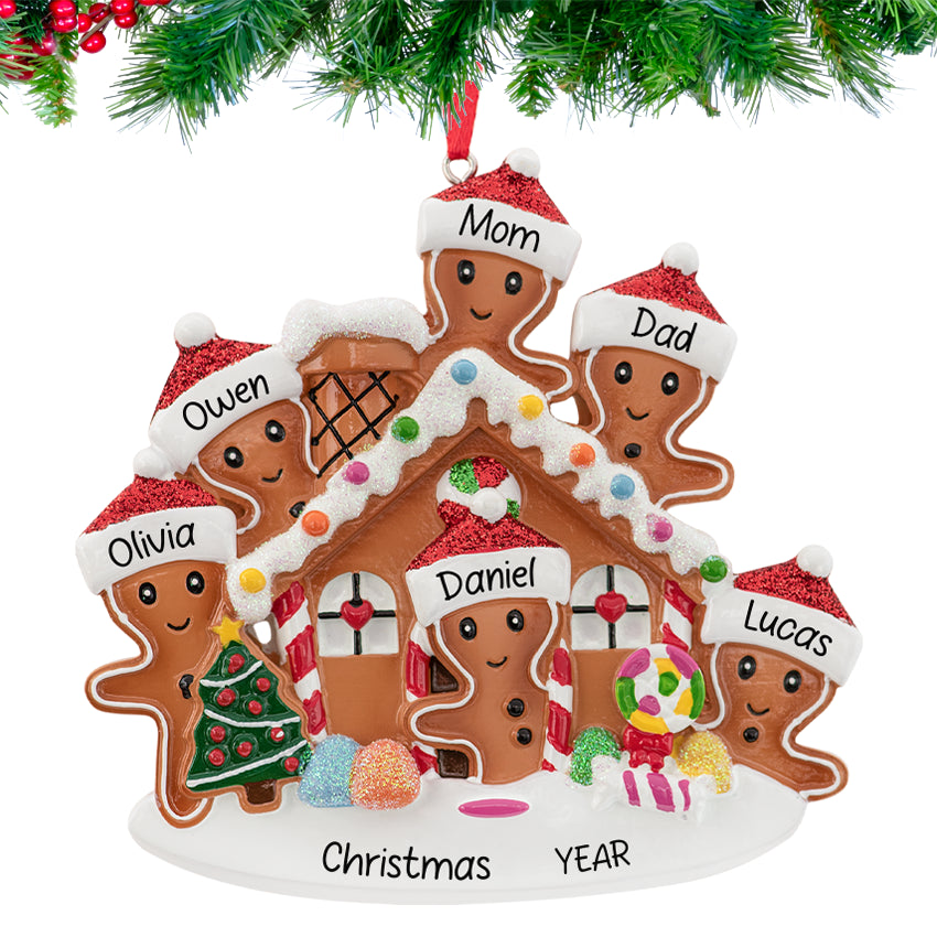 Gingerbread house ornament with a smiling family, personalized with names and 2025, hanging on a festive Christmas tree branch.