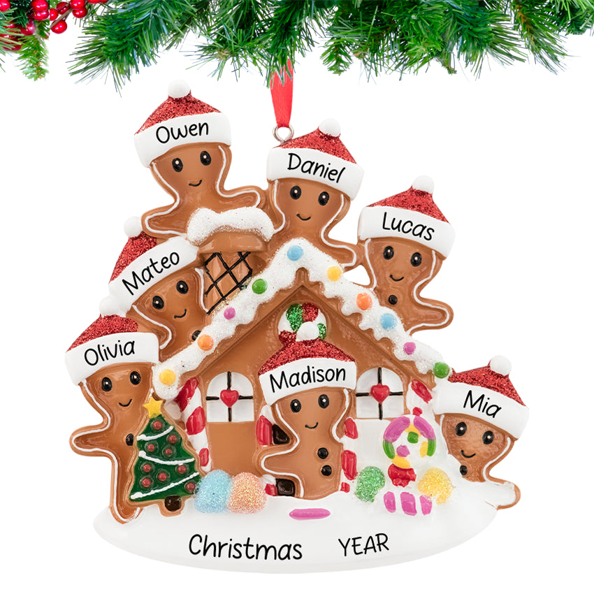 Gingerbread house ornament with a smiling family, personalized with names and 2025, hanging on a festive Christmas tree branch.