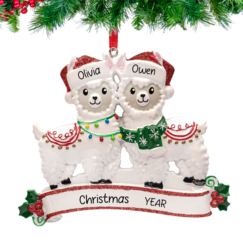 Two festive llamas wearing Santa hats and scarves, personalized with couple’s names and 2025, hanging on a decorated Christmas tree branch.