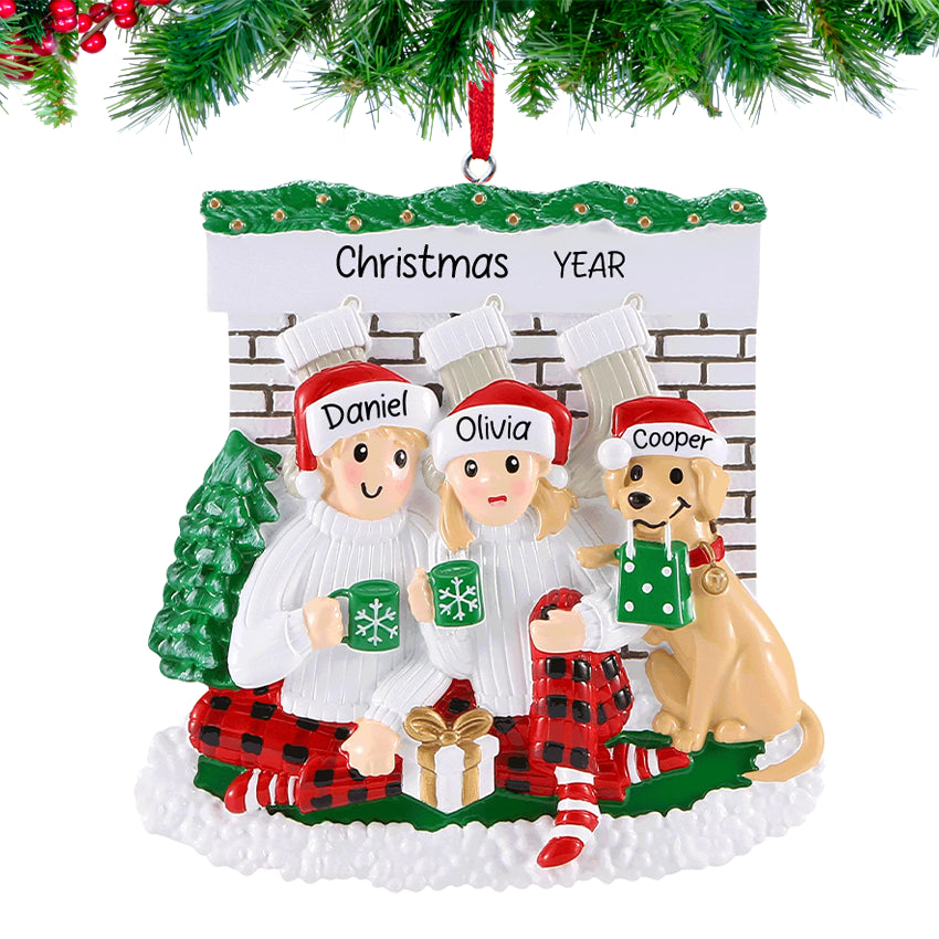 Couple and their dog relaxing by a glowing fireplace, personalized with names and 2025, hanging on a festive Christmas tree branch.