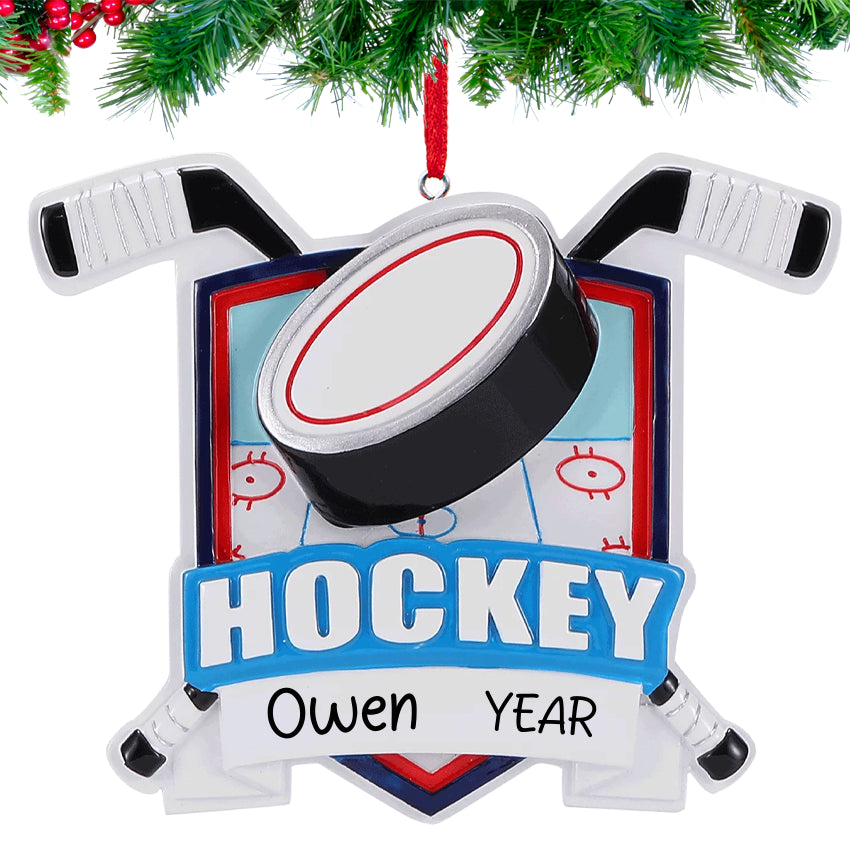 Hockey-themed Christmas ornament with sticks and puck design, hanging against a white background.