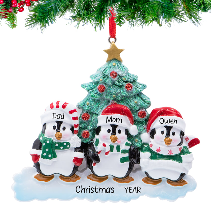 Penguin parents with chick, ornament personalized with three names and 2025, hanging on a snowy Christmas tree branch
