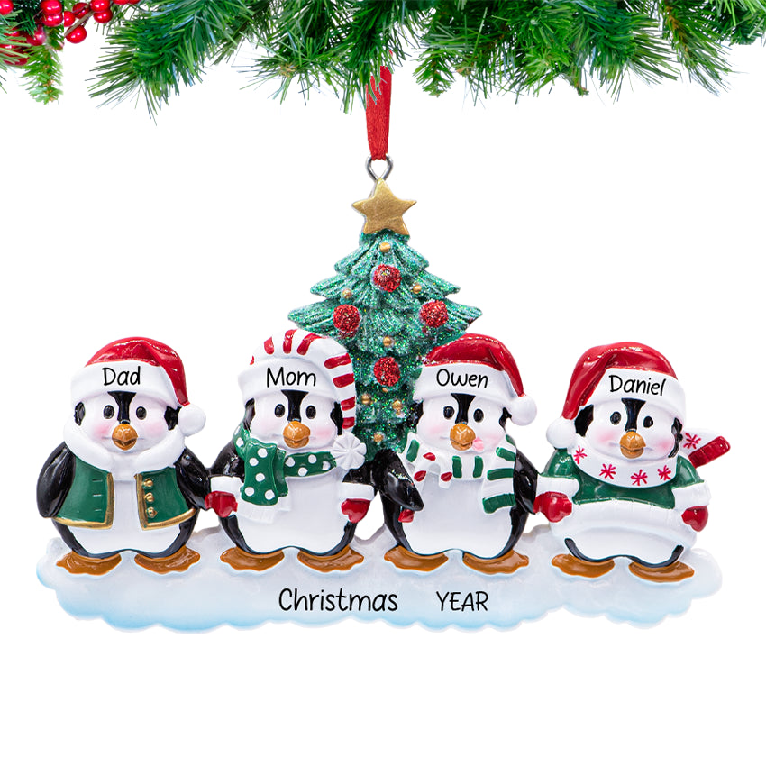 Penguin parents with two chicks, ornament personalized with four names and 2025, hanging on a snowy Christmas tree branch.