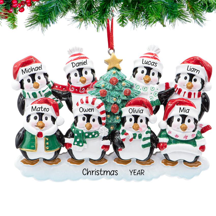 Penguin parents with six chicks, ornament personalized with eight names and 2025, hanging on a snowy Christmas tree branch.