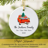 Personalized red truck ornament hanging on a Christmas tree branch