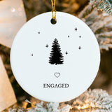Close-up of glossy porcelain ornament showing Christmas tree and ring design with fused names