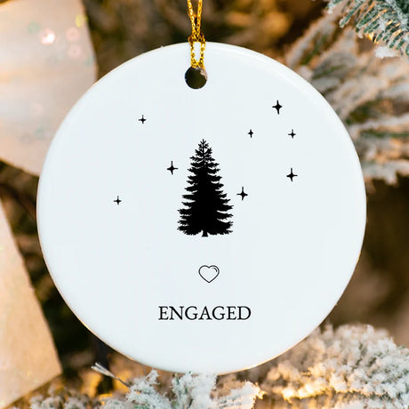 Close-up of glossy porcelain ornament showing Christmas tree and ring design with fused names