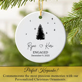 Engagement ornament hanging on a Christmas tree with warm fairy lights