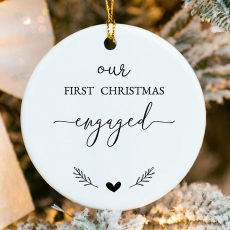 Close-up of porcelain ornament showing intertwined hearts, holly accents, and fused name printing