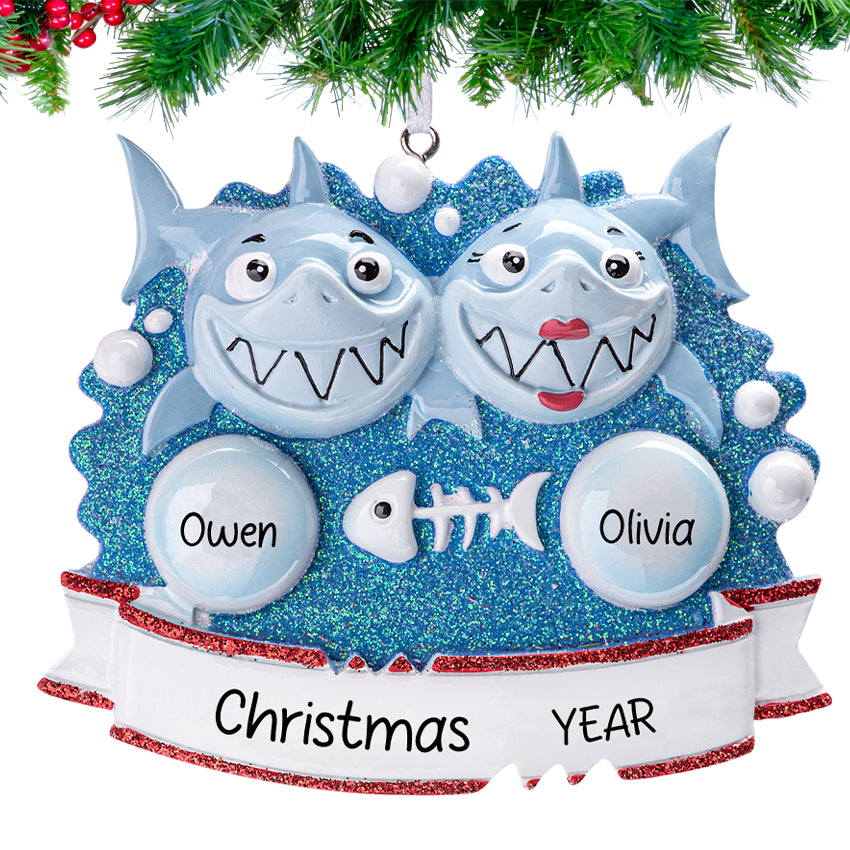 Two smiling sharks5, hanging on a festive Christmas tree branch.