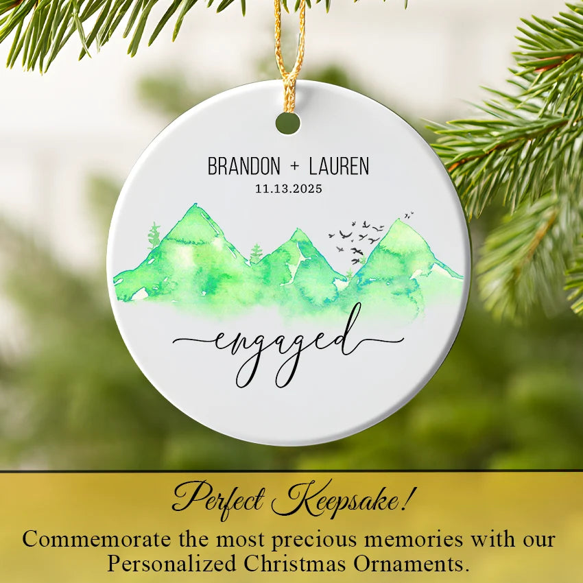 Engagement ornament hanging on a Christmas tree branch near pine needles
