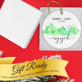 Hand holding the Green Mountain engagement ornament to show scale and personalization