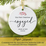 Custom engagement ornament hanging on a Christmas tree branch with pine needles and lights